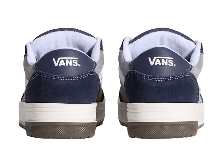 Tenis Vans Hylane en colores gris y azul marino con franja blanca y suela de goma marrón.