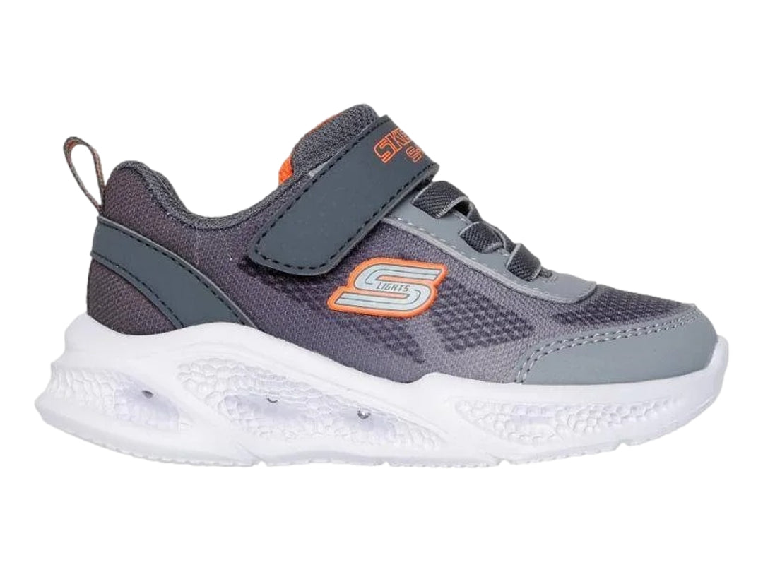 Tenis deportivos Skechers para niño en color gris con suela blanca y detalles en naranja.