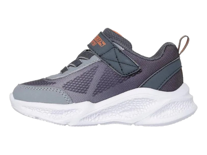 Tenis deportivos Skechers para niño en color gris con suela blanca y detalles en naranja.