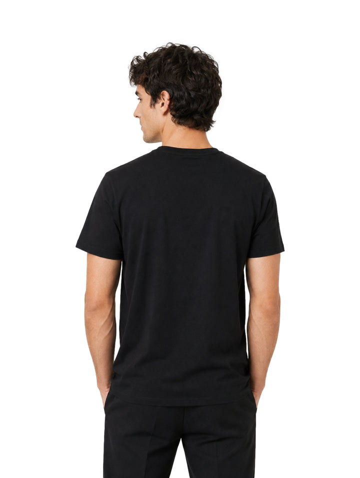 Hombre vistiendo playera Givenchy color negro de manga corta con logotipo blanco en el pecho.