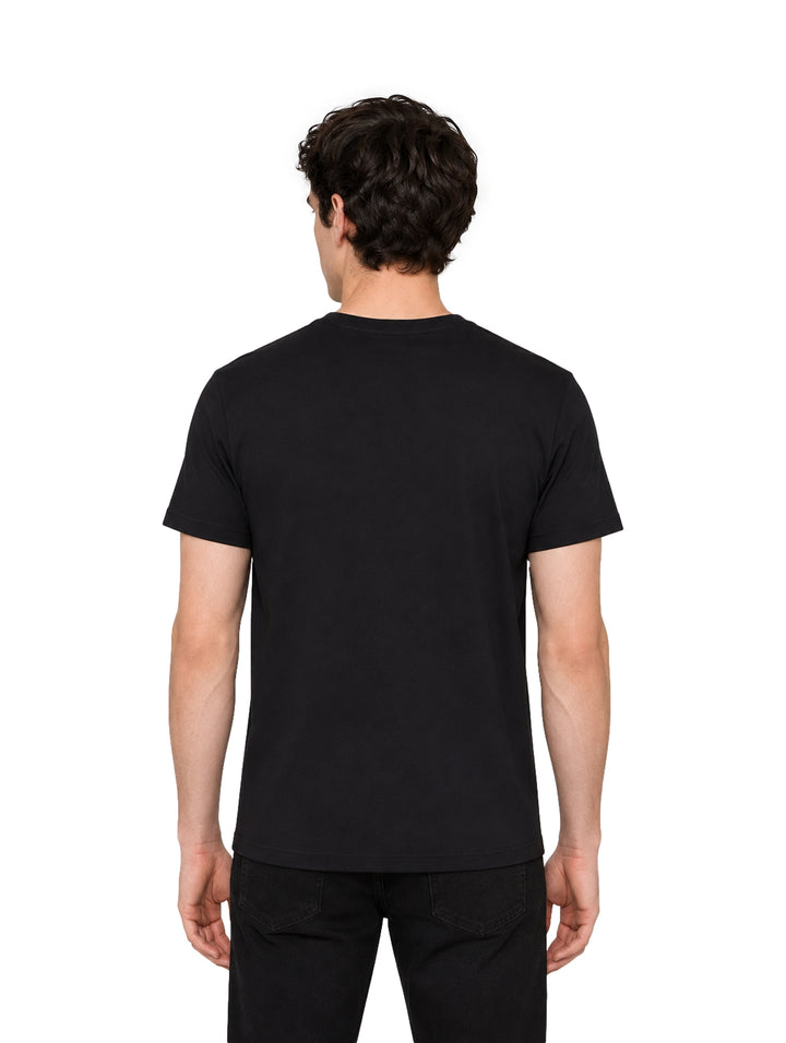 Hombre vistiendo playera Givenchy color negro de manga corta con logotipo frontal en color verde lima.