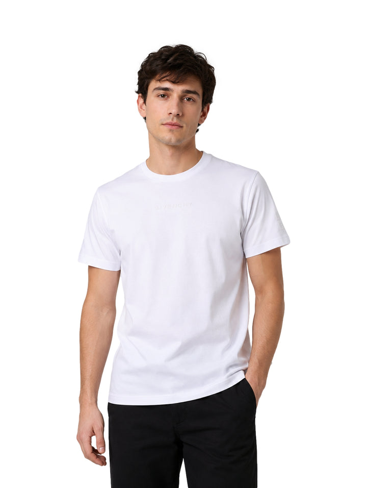 Hombre vistiendo una playera Givenchy de color blanco con manga corta y cuello redondo.