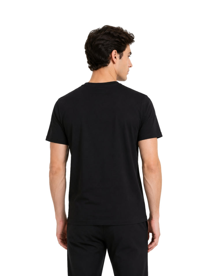 Hombre vistiendo playera negra de manga corta con logotipo de Givenchy en el pecho.