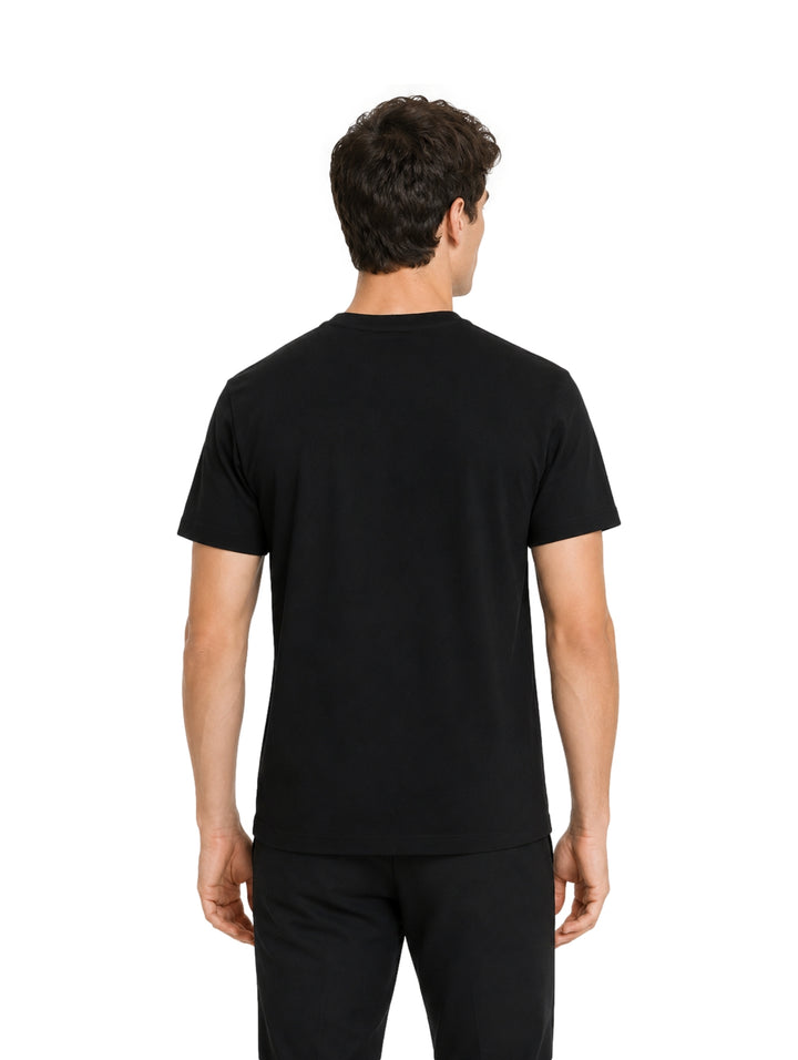 Hombre vistiendo playera Givenchy color negro con logotipo rojo en el pecho.