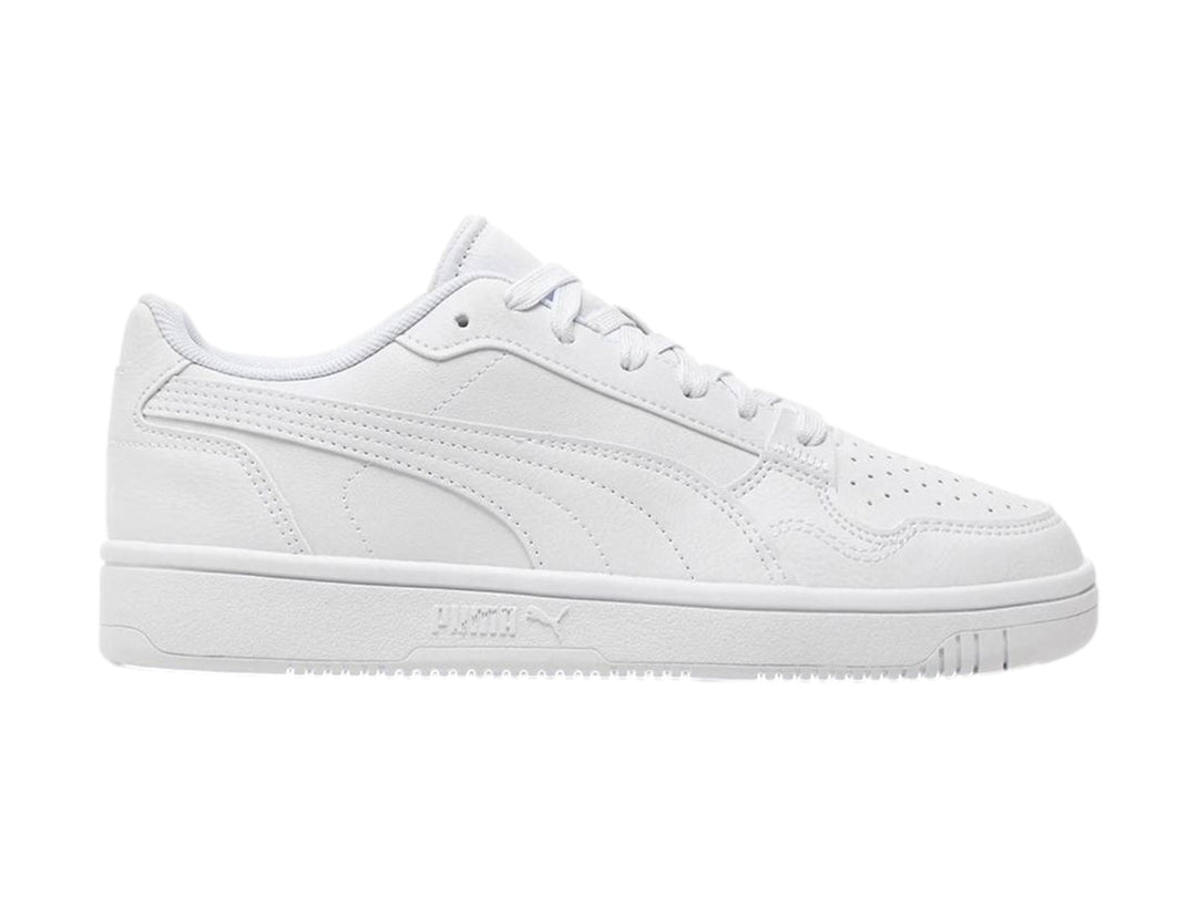 Tenis PUMA blancos para niños, de corte bajo con cordones y suela plana.