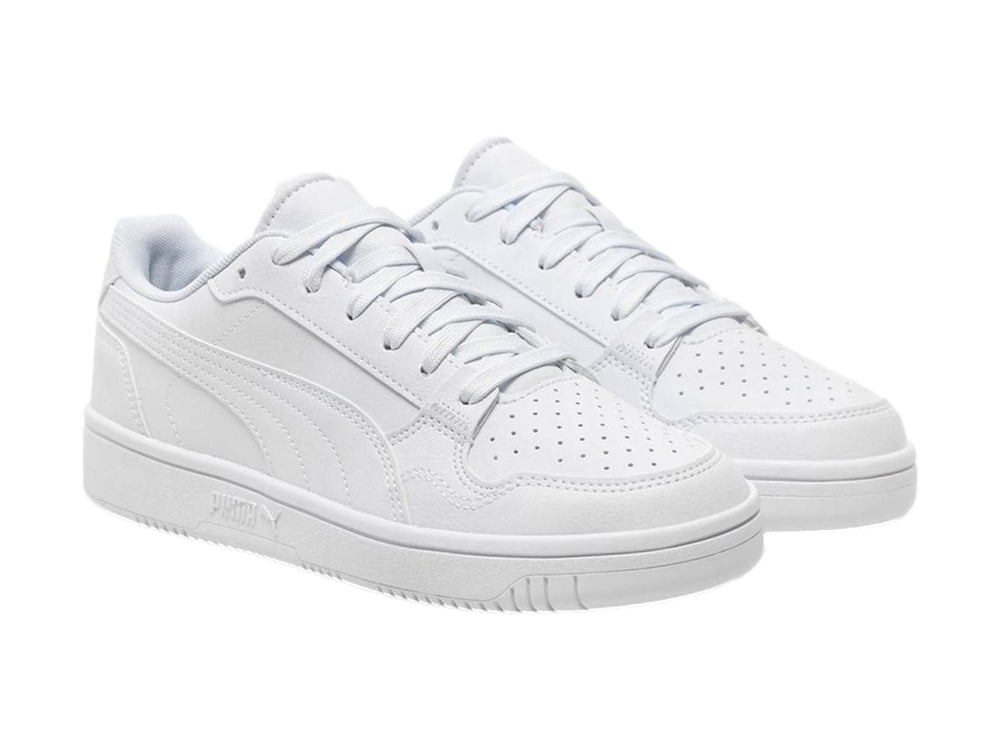 Tenis PUMA blancos para niños, de corte bajo con cordones y suela plana.