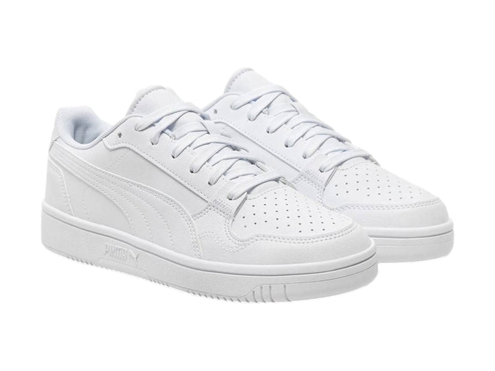 Tenis PUMA blancos para niños, de corte bajo con cordones y suela plana.