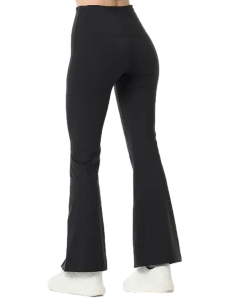 Mujer vistiendo leggings deportivos negros de talle alto con abertura en el tobillo.