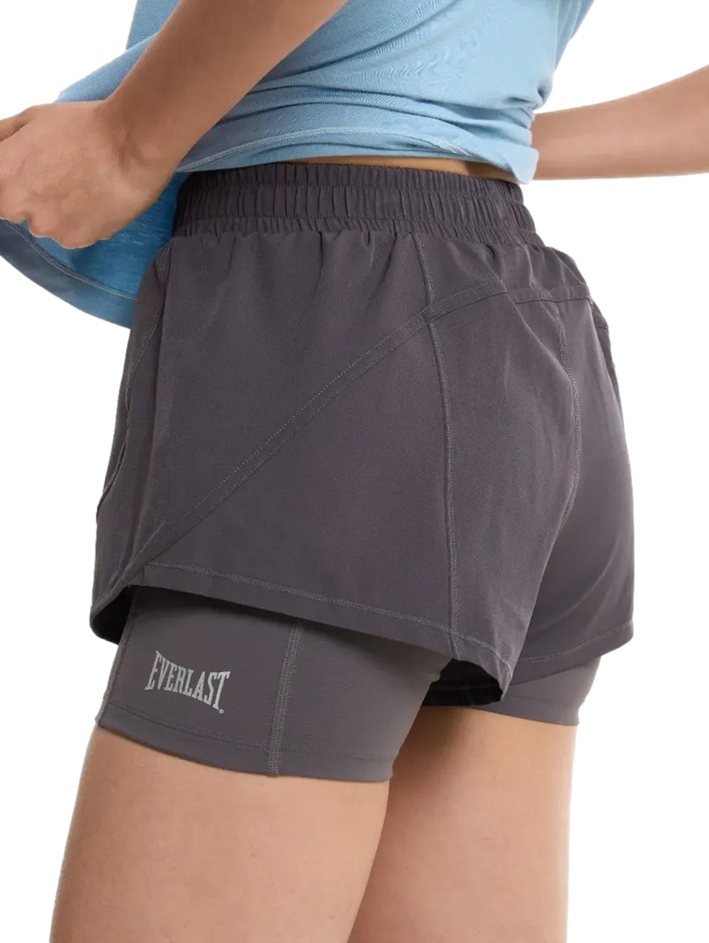 Mujer vistiendo shorts deportivos color gris de la marca Everlast.