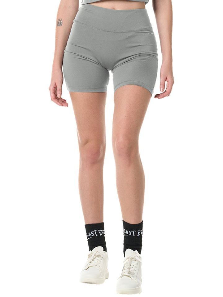 Mujer vistiendo mallas deportivas cortas color gris de cintura alta marca Everlast.