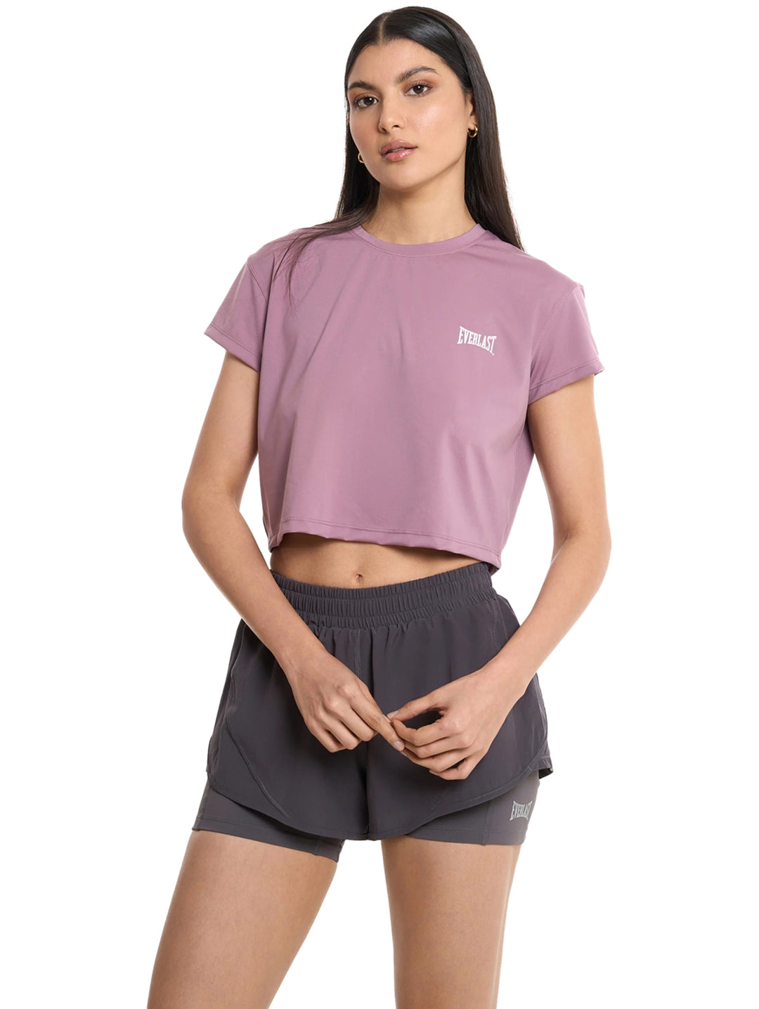 Mujer modelando un crop top deportivo color rosa de la marca Everlast.