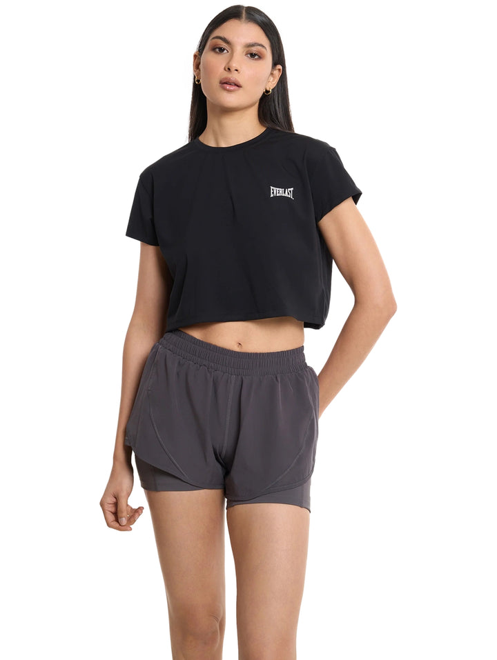 Mujer vistiendo una camiseta crop top negra de manga corta marca Everlast para fitness.