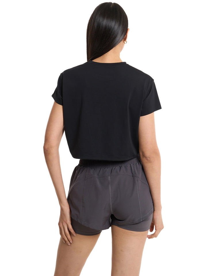 Mujer vistiendo una camiseta crop top negra de manga corta marca Everlast para fitness.