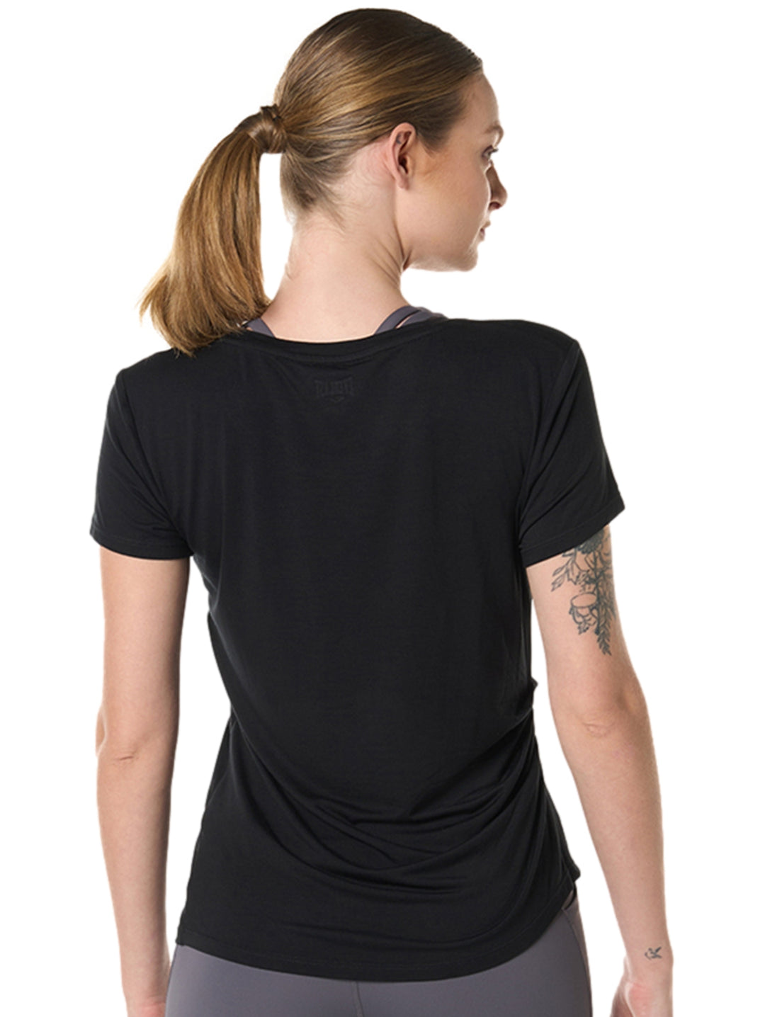 Mujer vistiendo una camiseta deportiva negra de manga corta marca Everlast.