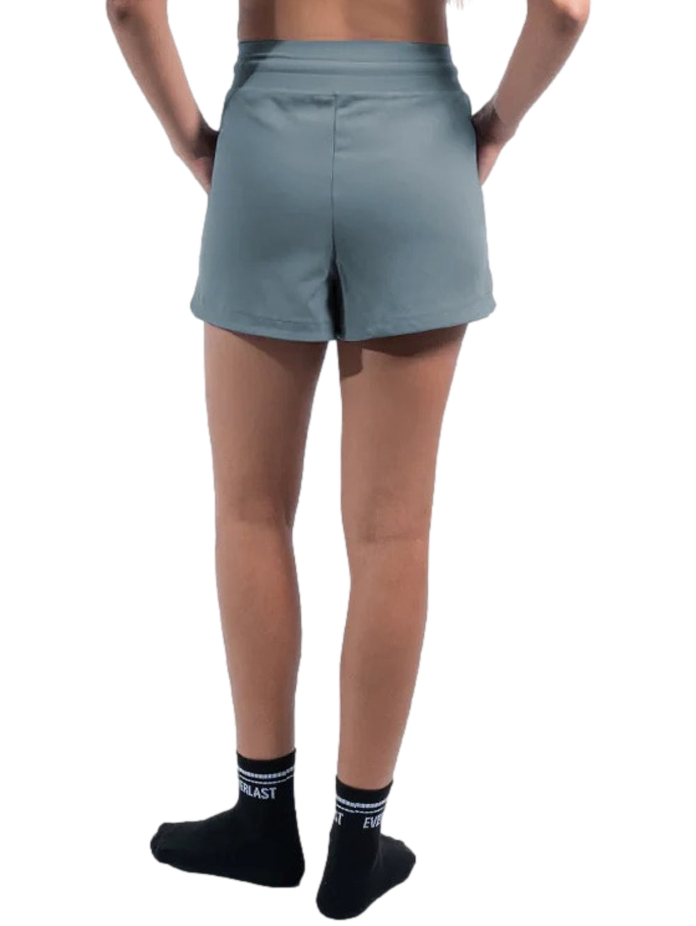 Mujer vistiendo shorts deportivos color azul con bolsillos laterales y cintura ajustable.