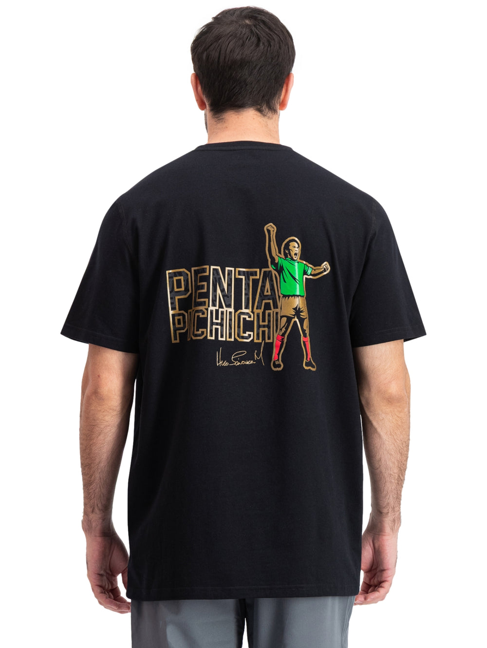 Hombre vistiendo playera deportiva negra de manga corta con detalles dorados en el pecho.