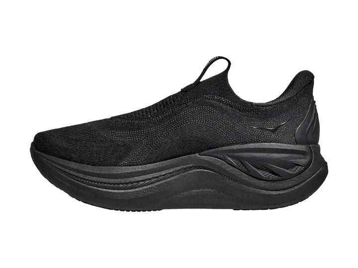 Tenis deportivos HOKA color negro, diseño sin cordones y suela gruesa.
