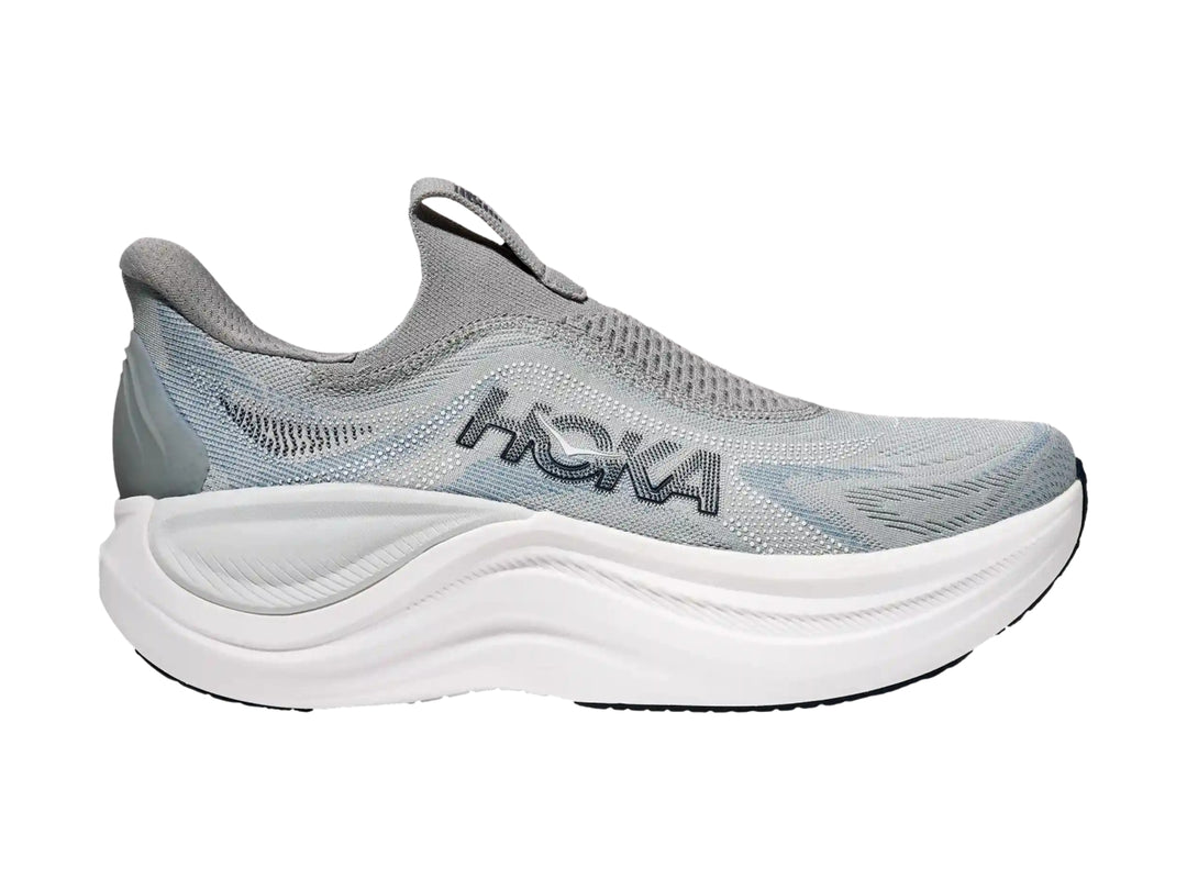 Tenis deportivos HOKA color gris con suela blanca gruesa, diseño sin cordones y tejido transpirable.