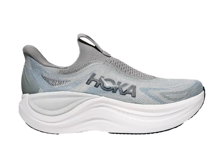 Tenis deportivos HOKA color gris con suela blanca gruesa, diseño sin cordones y tejido transpirable.