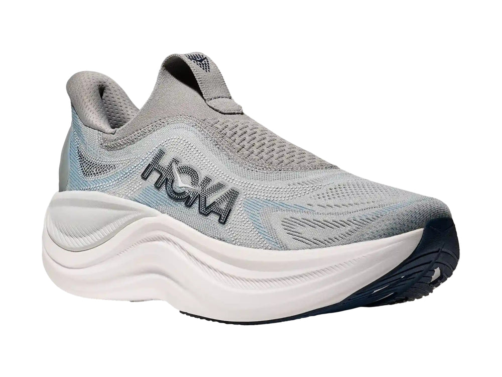 Tenis deportivos HOKA color gris con suela blanca gruesa, diseño sin cordones y tejido transpirable.