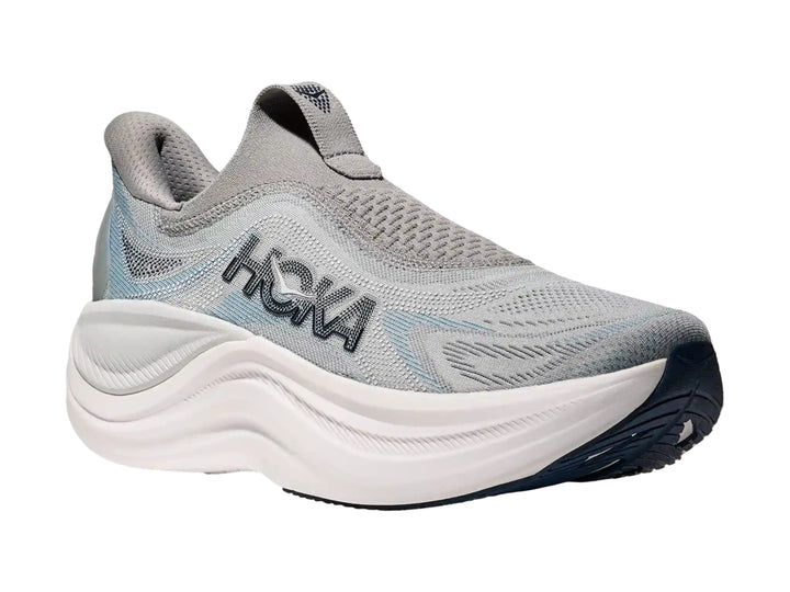 Tenis deportivos HOKA color gris con suela blanca gruesa, diseño sin cordones y tejido transpirable.