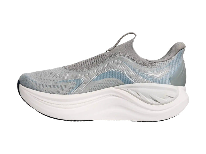 Tenis deportivos HOKA color gris con suela blanca gruesa, diseño sin cordones y tejido transpirable.