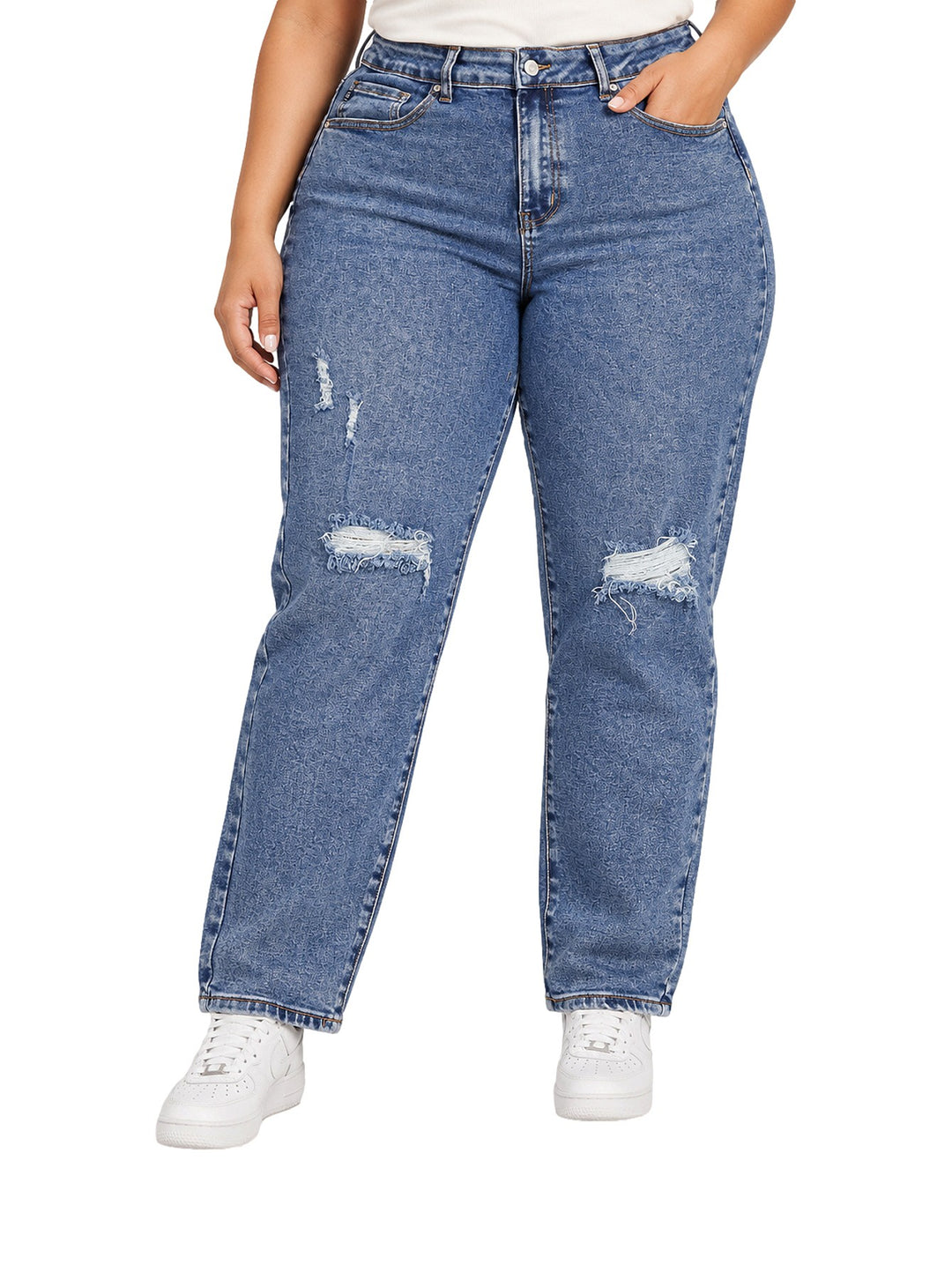 Mujer vistiendo jeans mom de color azul medio con detalles desgastados y rotos en las rodillas.