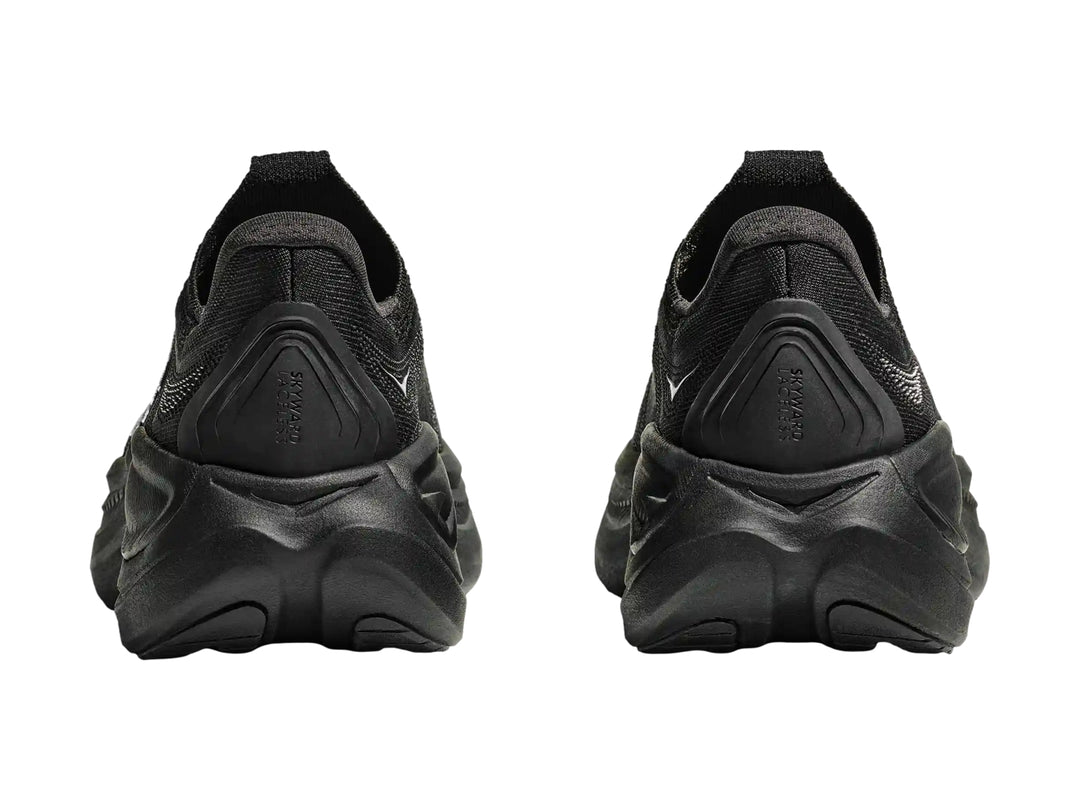 Tenis deportivos Hoka color negro, diseño sin agujetas y suela gruesa.
