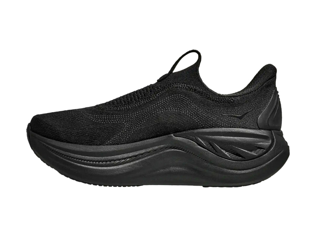 Tenis deportivos Hoka color negro, diseño sin agujetas y suela gruesa.