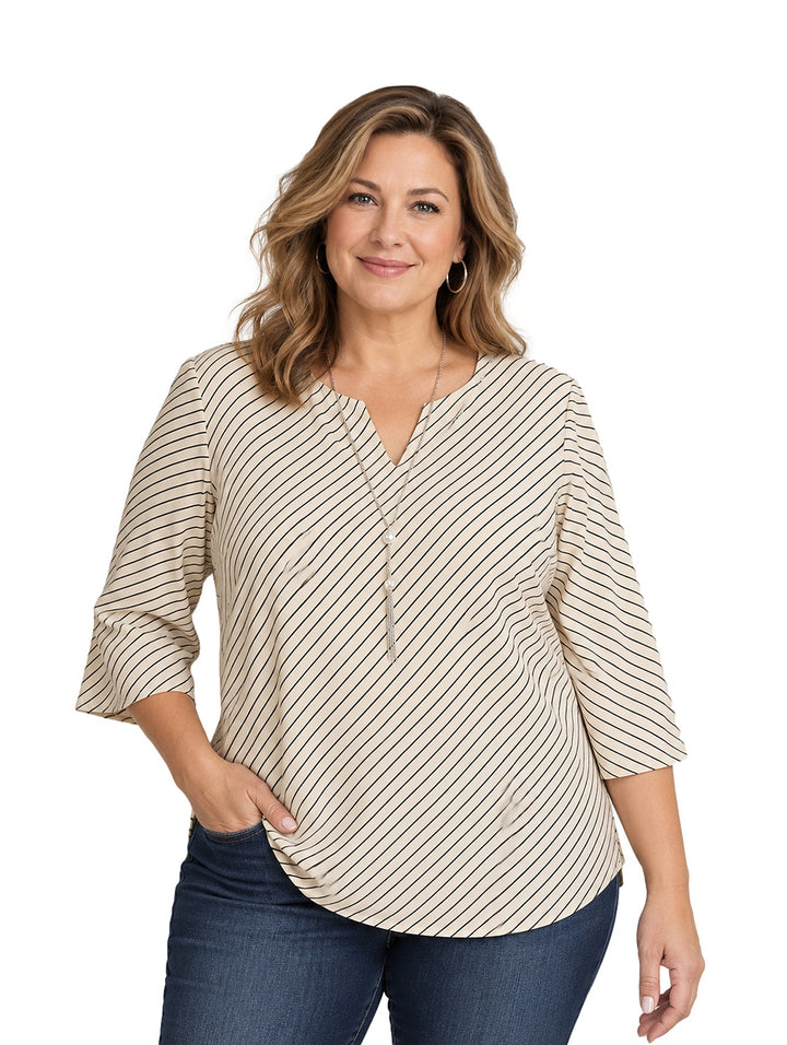 Mujer vistiendo blusa curvy color beige con rayas negras diagonales, cuello en V y manga tres cuartos.