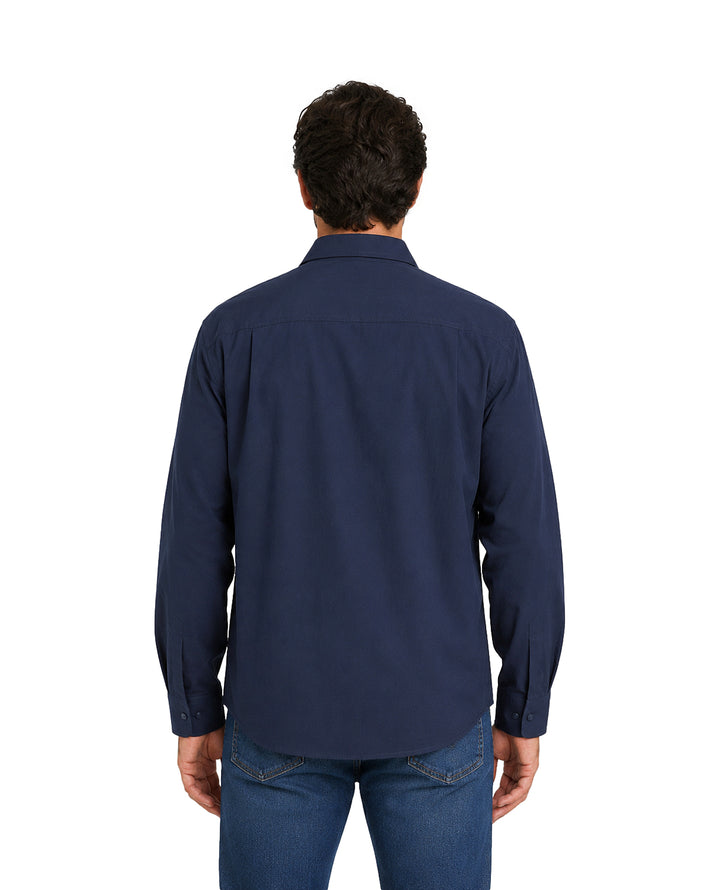 Hombre vistiendo una camisa azul marino de manga larga con un bolsillo frontal.