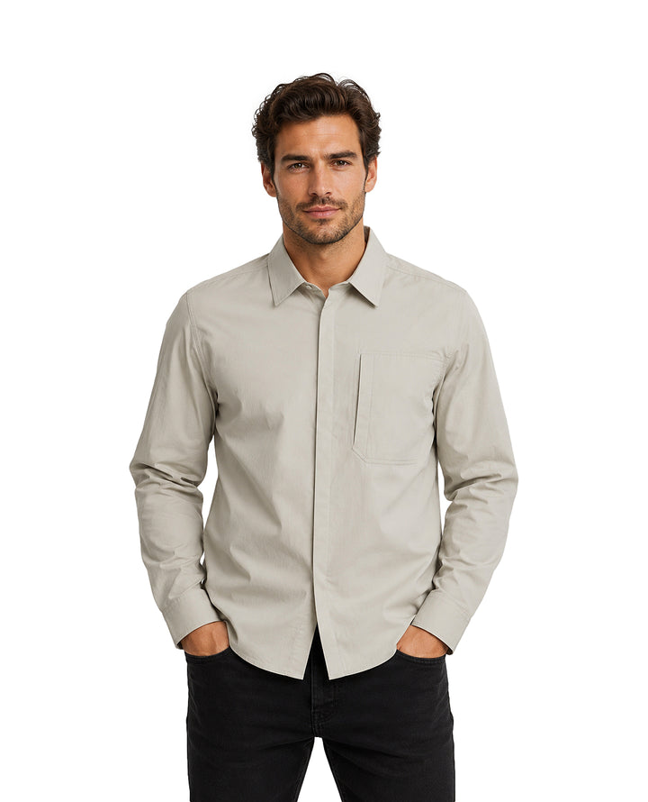 Hombre vistiendo una camisa gris de manga larga con cuello y bolsillo frontal.