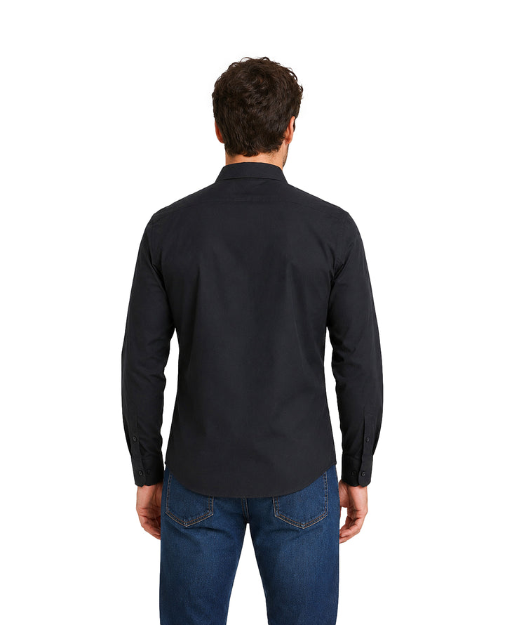 Hombre vistiendo una camisa negra de manga larga y pantalones vaqueros azules.