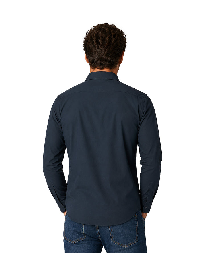 Hombre vistiendo una camisa de manga larga color azul marino y pantalones de mezclilla.
