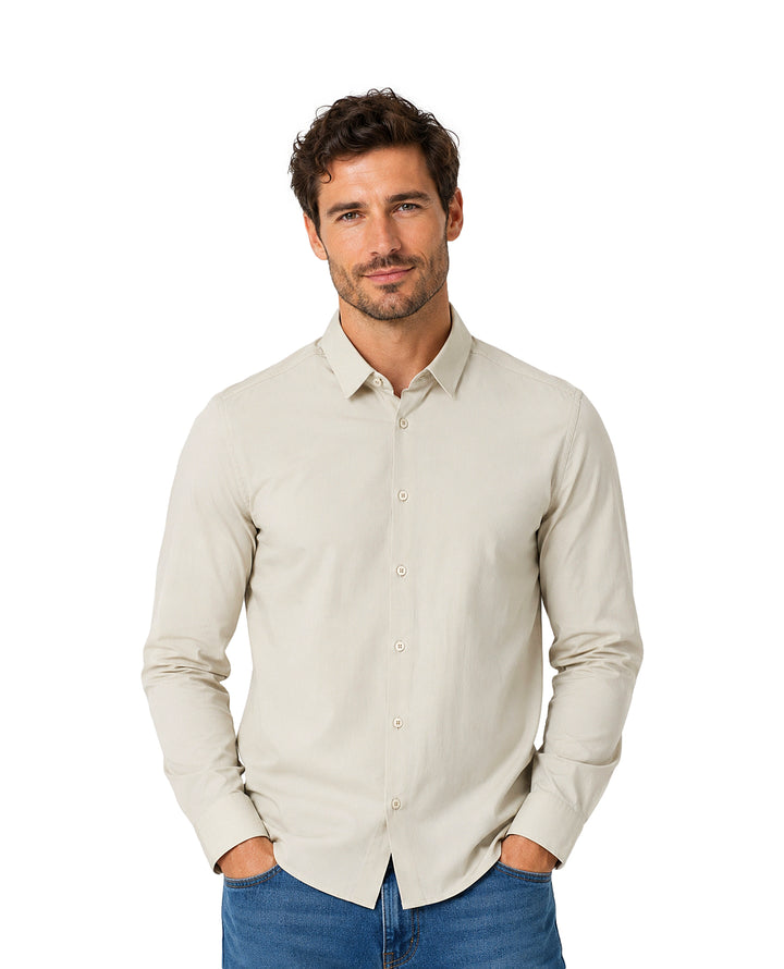 Hombre vistiendo una camisa de manga larga color beige y pantalones azules.