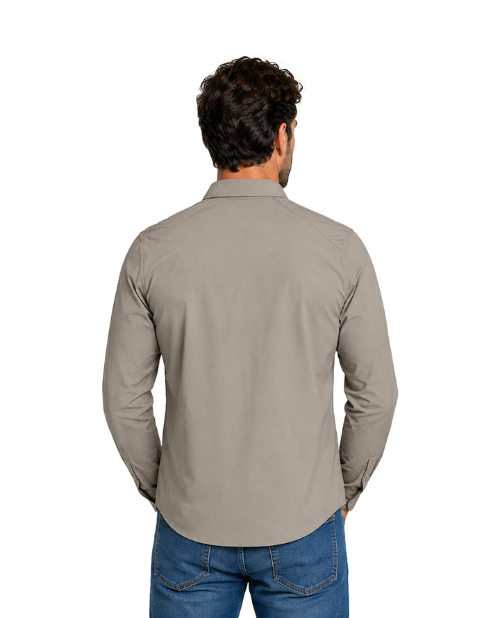 Hombre vistiendo camisa de manga larga color gris y pantalones azules.