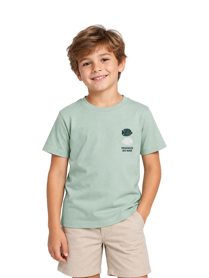 Niño vistiendo playera Zippy color verde claro con estampado de peces y texto en el pecho.