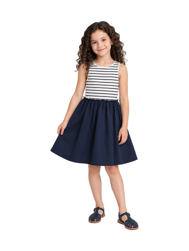 Niña vistiendo un vestido Zippy azul oscuro con parte superior a rayas blancas y azules y sandalias azules.