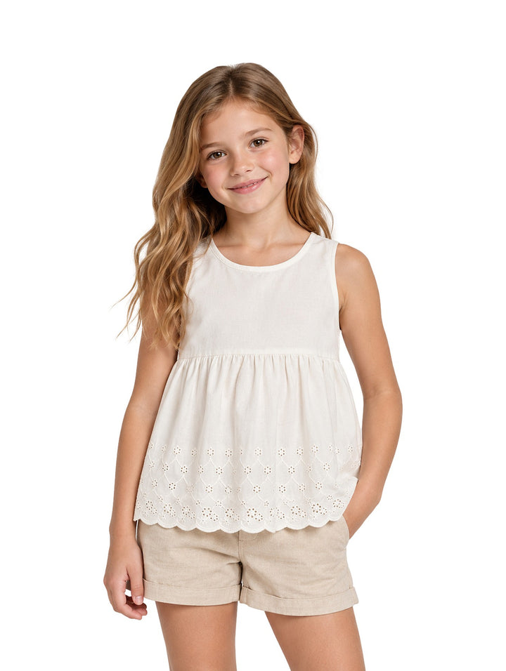 Niña vistiendo un conjunto de blusa beige claro con detalles calados y shorts a juego de la marca Zippy.