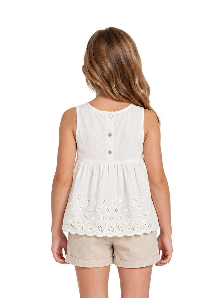 Niña vistiendo un conjunto de blusa beige claro con detalles calados y shorts a juego de la marca Zippy.