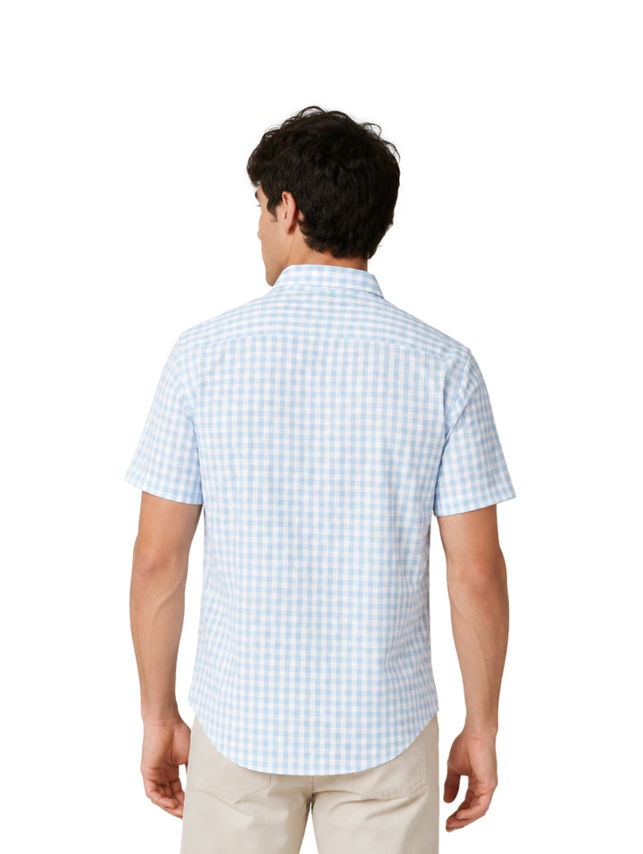 Hombre vistiendo camisa de manga corta con estampado de cuadros azul claro y blanco.
