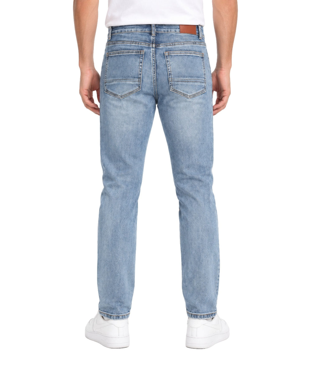 Hombre vistiendo jeans Kahua color azul medio con detalles desgastados y rotos en las piernas.