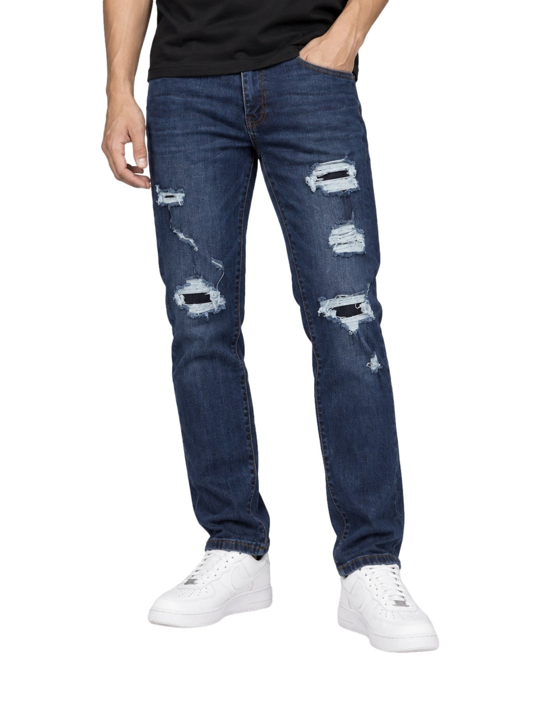 Hombre vistiendo jeans Kahua de color azul oscuro con detalles rotos y desgastados en las piernas.