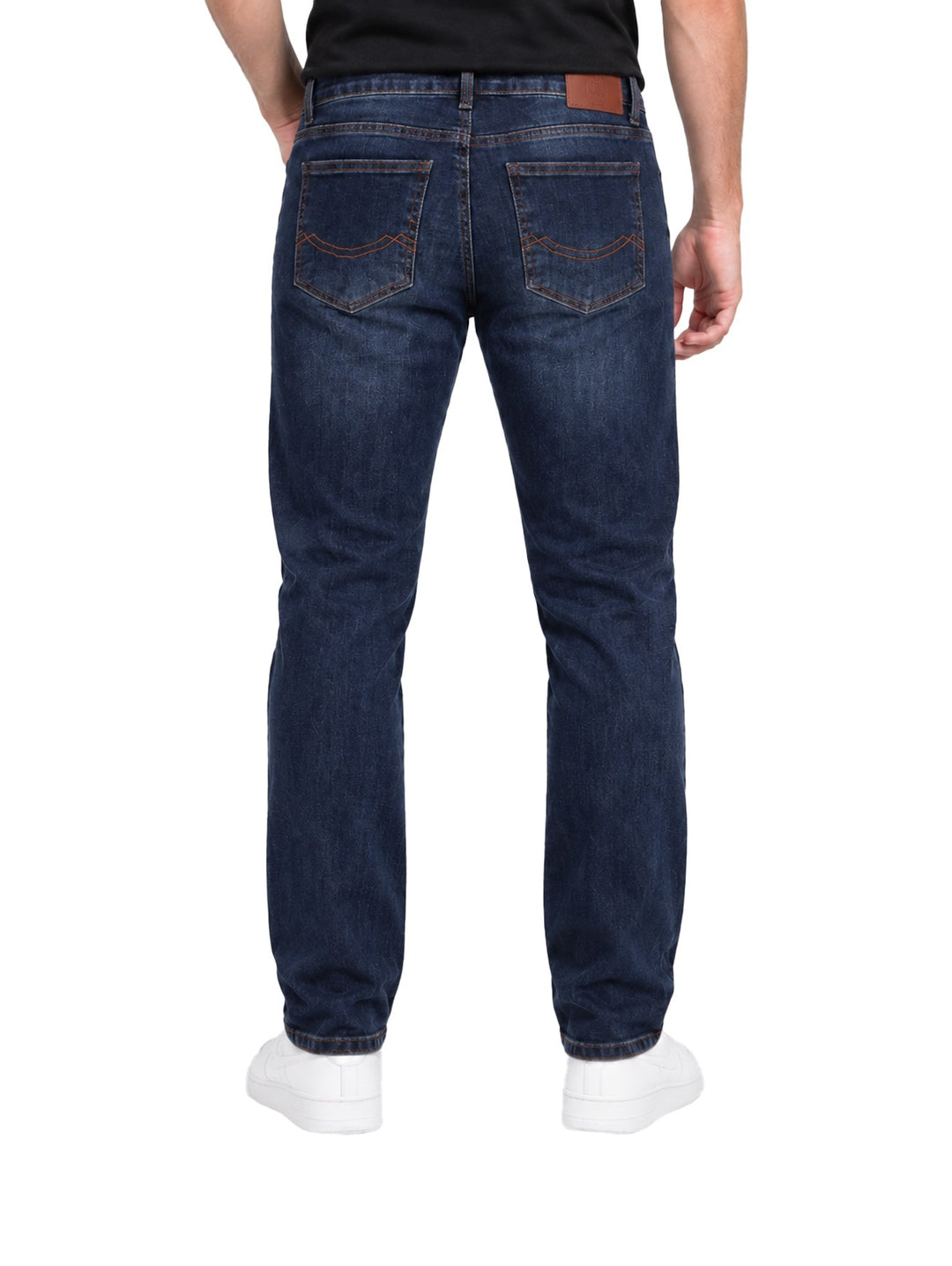 Hombre vistiendo jeans Kahua de color azul oscuro con detalles rotos y desgastados en las piernas.