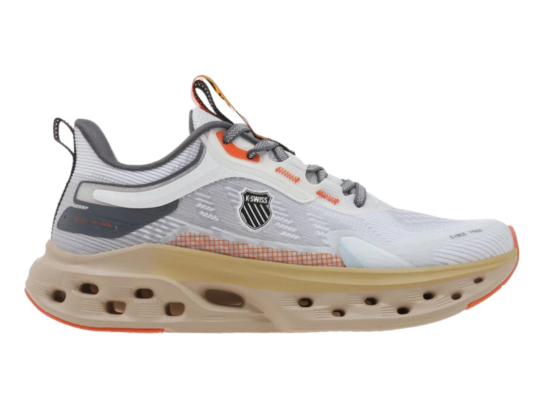 Tenis deportivos K-Swiss color blanco y arena con suela gruesa perforada y detalles en naranja.