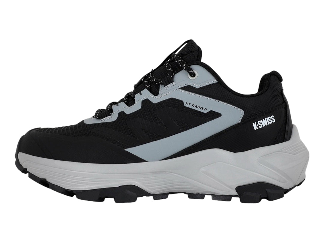 Tenis deportivos K-Swiss color negro y gris con suela gruesa y cordones moteados.