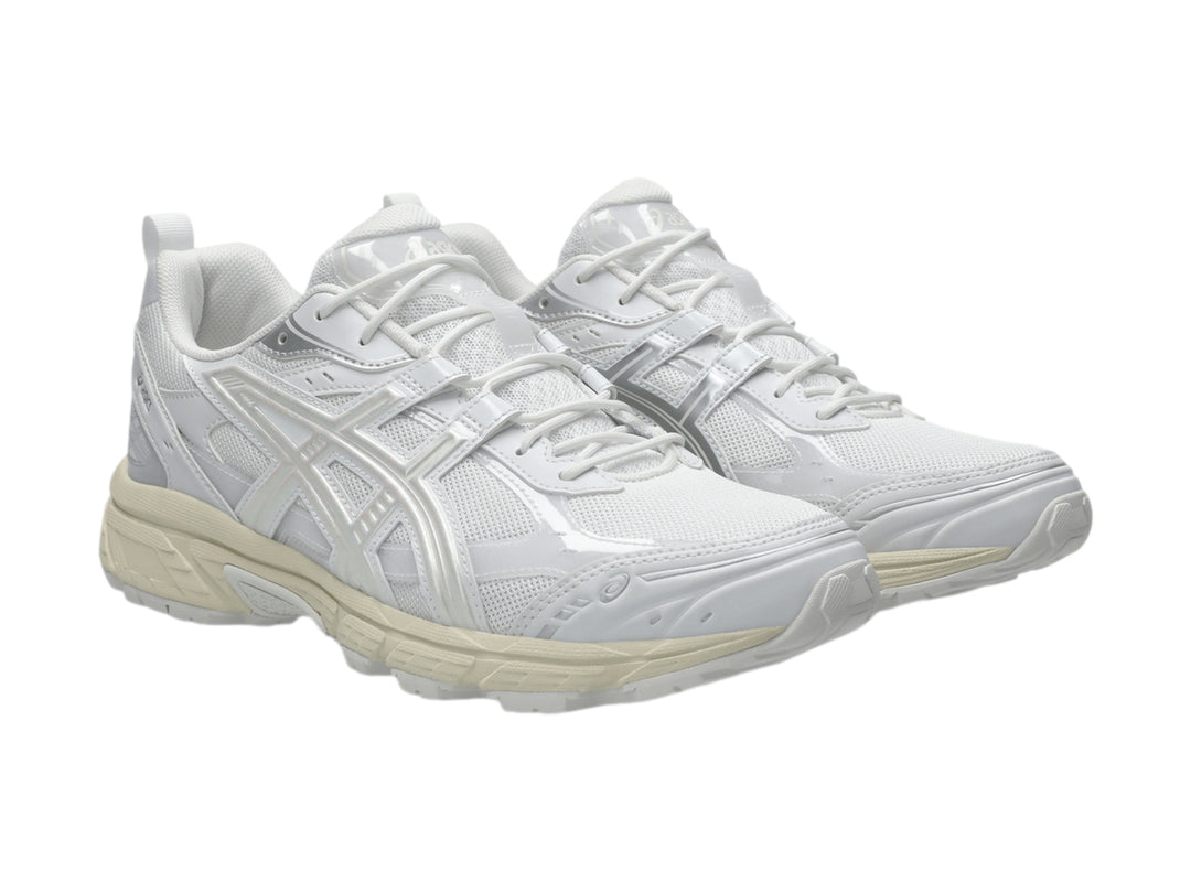 Tenis deportivos ASICS color blanco y crema con detalles de malla y suela robusta.