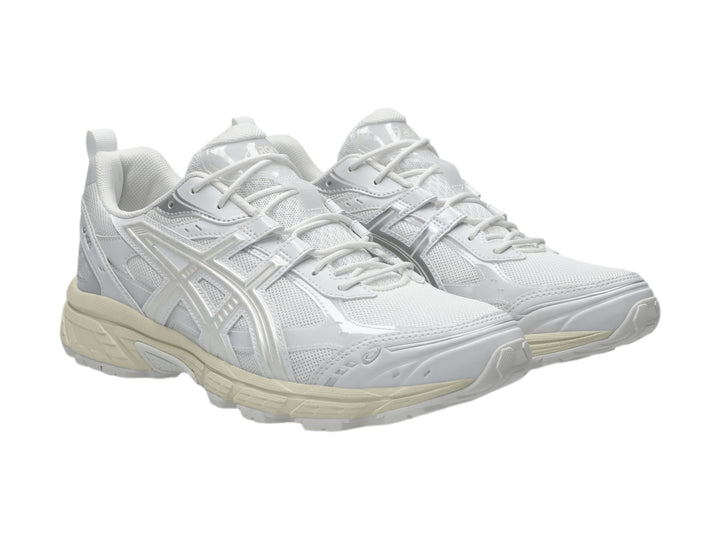 Tenis deportivos ASICS color blanco y crema con detalles de malla y suela robusta.
