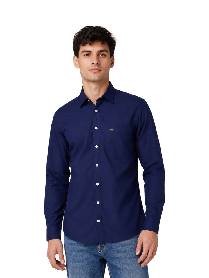 Hombre vistiendo una camisa Lee de color azul marino de manga larga y botones frontales.