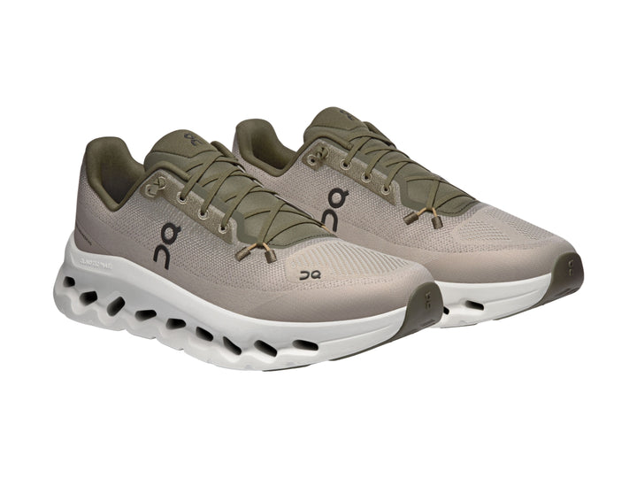 Tenis deportivos On Cloud color oliva con suela blanca y diseño moderno.